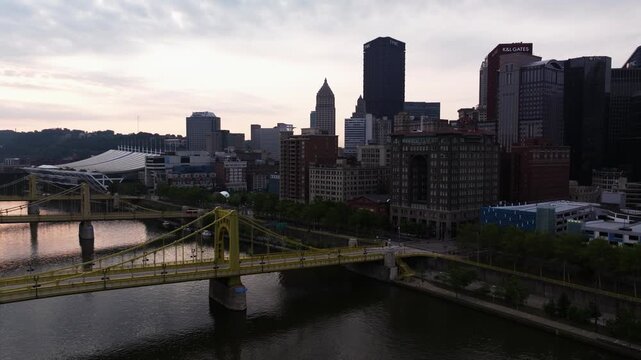 Roberto Clemente Bridge and downtown Pittsburgh skyline beside Allegheny River, aerial ascend backdrop reveals skyline