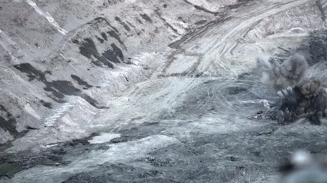 Spectacular slow motion explosion at open pit mine site with massive smoke and rock debris flying