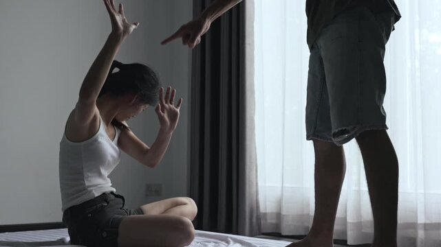 Dramatic silhouette of a distressed woman and an angry male partner, illustrating family conflict, personal safety, prevention, and support services.