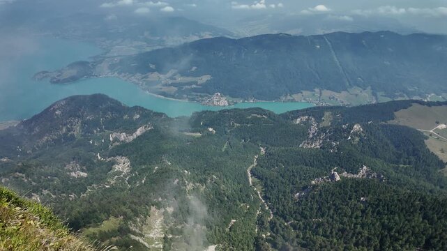 Misty landscape with mountain lake in nature. Mountain peak aerial view. Aerial misty landscape. Scenic nature over lake. Mountain peaks in mist. Aerial view of mountain landscape. Landscape panorama
