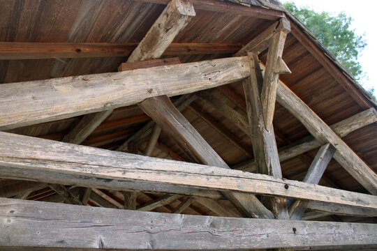 Charpente traditionnelle en bois apparente avec poutres massives et voligeage sous toiture