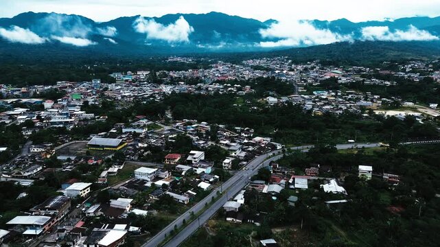 Aerial View of Ecuador Town in Green Mountain Valley with Dense Buildings, Forested Hills, Roads and Scenic Andean Travel Landscape Background