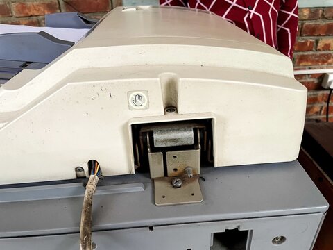 Closeup of the hinge mechanism and wiring on the back of an old office photocopier