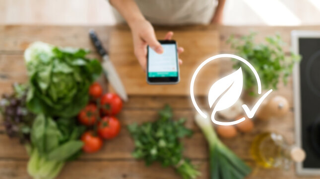 Hand Holding Smartphone Over Fresh Produce with Leaf Icon Organic Food and Healthy Eating Concept