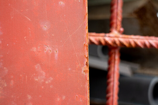 Red rusty metal plate close up detail with textured surface texture background