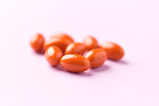 Lutein capsules. Dietary supplement on bright paper background. Soft focus. Close up. Copy space.