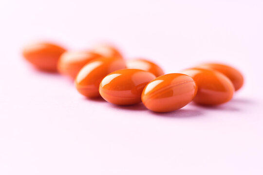 Lutein capsules. Dietary supplement on bright paper background. Soft focus. Close up. Copy space.