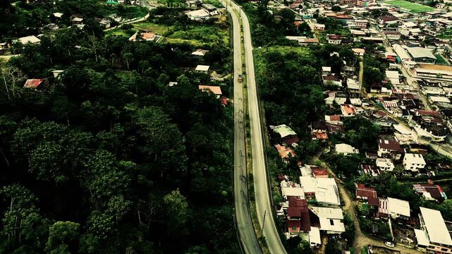 Top Down Drone View of Road Through Tropical Ecuador Town with Houses, Forest Patches, Green Lots and Rural Urban Infrastructure Pattern