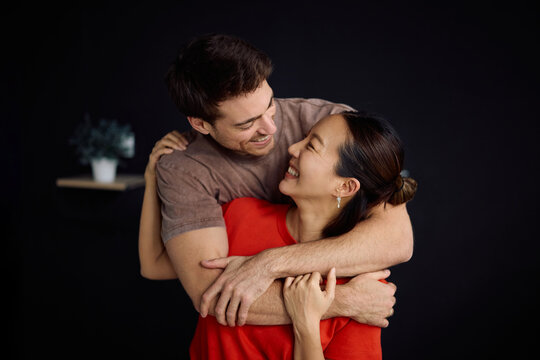 Happy embraced couple talking face to face.