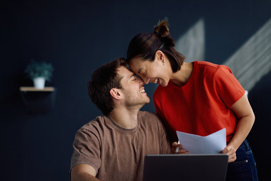 Affectionate couple having fun while working at home.