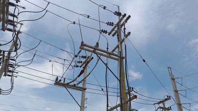 Pan right video from an incoming riser pole to a high voltage circuit , industrial electrical power grid distribution network infrastructure.