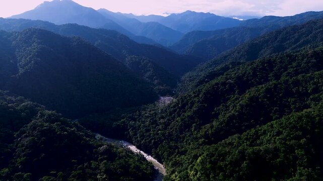 Aerial View of Deep Tropical Mountain Valley in Ecuador with Forested Slopes, Winding Road, Blue Haze and Remote Andean Amazon Landscape