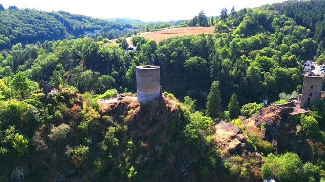 Aerial Drone Orbit Around Medieval Castle Tower Ruins in Lush Forest Valley, Luxembourg