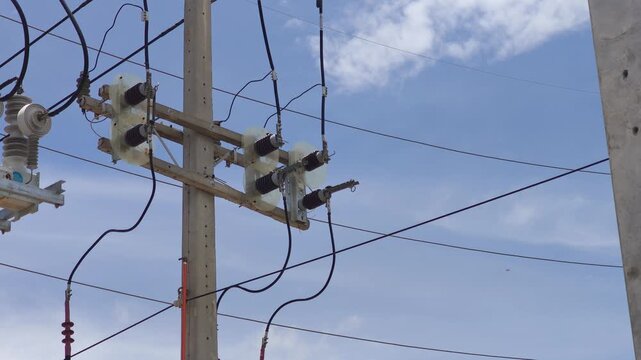 Video of preparing to open a disconnect switch on a riser pole using a hot stick, industrial high voltage electrical power grid distribution network maintenance.