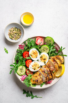 High protein lunch bowl with chicken, eggs and vegetable salad.