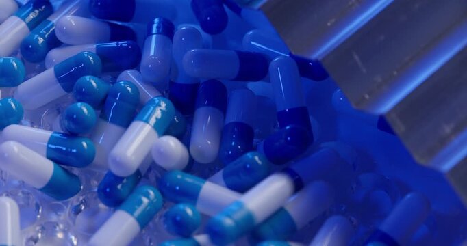 Slow motion blue and white capsules tumbling into clear plastic tray on pharmaceutical production line in laboratory setting.
