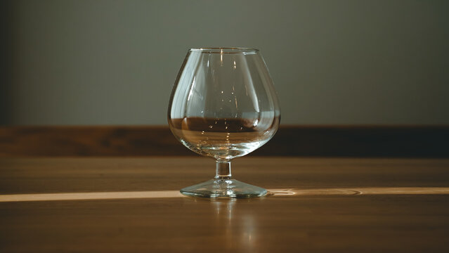 Empty brandy snifter glass on a wooden table