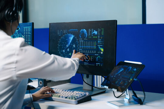 Air traffic control operators wearing headsets monitor live flight radar and navigate airspace data on screens