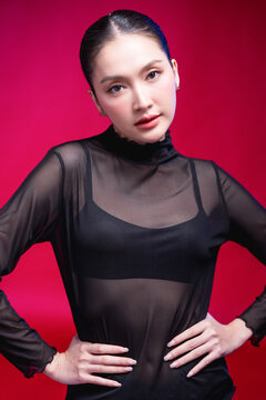 A bold woman points directly at the camera with a confident smirk, dramatic foreground blur and sharp gaze against a vivid red backdrop, radiating attitude and defiance.