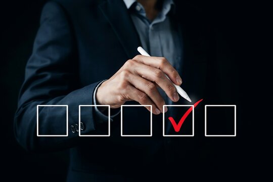 Person in dark suit checking boxes on a digital form using a white stylus pen