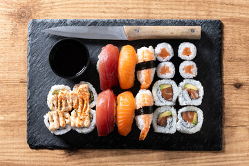 Assorted sushi platter with salmon, tuna, shrimp and rolls on wooden table. Top view © chandlervid85