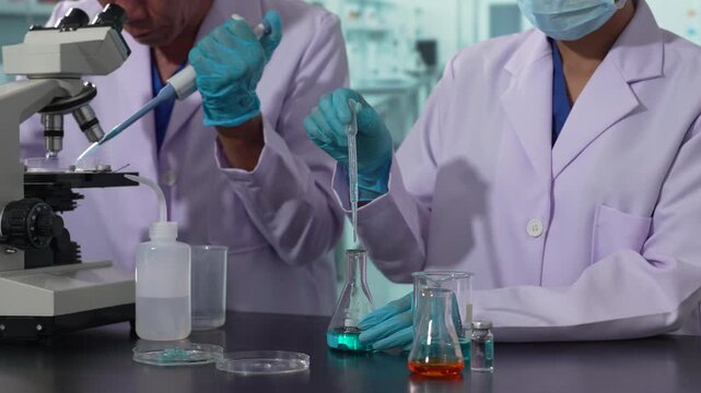 Lab work, scientists holds a test tube takes the test from a test tube in analysis for vaccine development.