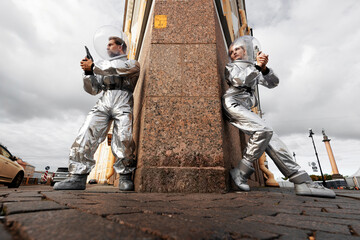 Two astronauts in an ambush behind a granite ledge with weapons ready, tension and spy scene © Ulia Koltyrina