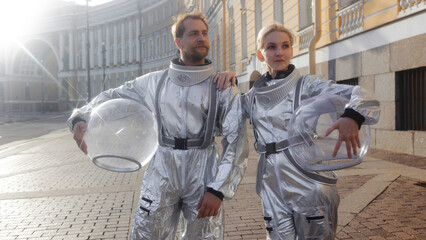 Horizontal banner with two astronauts in the morning sun on an old street, wide layout with copy space © Ulia Koltyrina