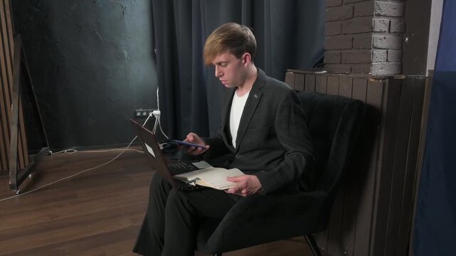 Focused Businessman Working Remotely with Laptop and Smartphone in a Modern Office