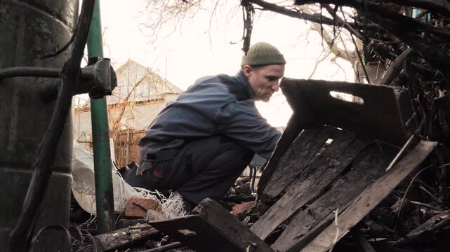 Volunteer cleaning up debris and destruction in a war-torn residential area