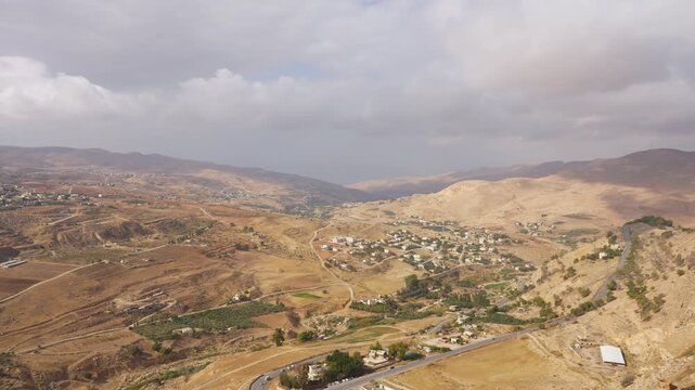 desert landscape and winding valley roads viewed from the high stone walls of Kerak Castle, Jordan.