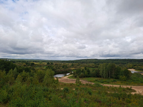 Expansive natural landscape with winding river under cloudy sky