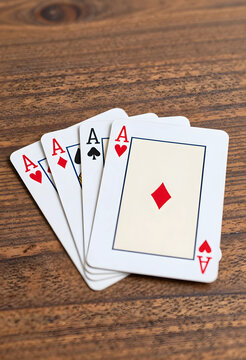 Gambling success and winning strategy, four aces playing cards on a wooden table risk management and business competition in a casino