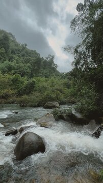 Bang Hua Rat Waterfall with lush jungle and flowing river.