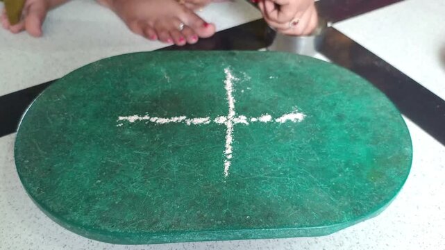 Traditional Hindu Ritual Rangoli Design with Rice Flour and Devotee Performing Puja