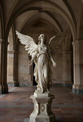 Fototapeta premium Spirituality and divine grace, marble angel statue with wings spread in a historic cathedral corridor for religious peace and afterlife contemplation