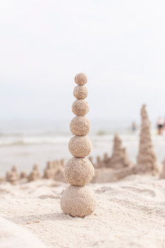 Sandkugeln bauen. Turm aus Sandkugeln. Aktivit&auml;t am Sandstrand.