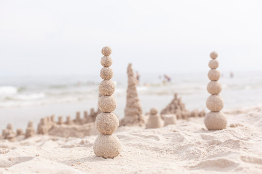 Sandkugeln bauen. Turm aus Sandkugeln. Aktivit&auml;t am Sandstrand.