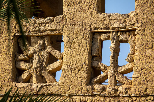 Close-up of a carved mudbrick lattice window framed by a weathered wooden lintel, Ad Dakhiliyah Region, Al Hamra, Oman