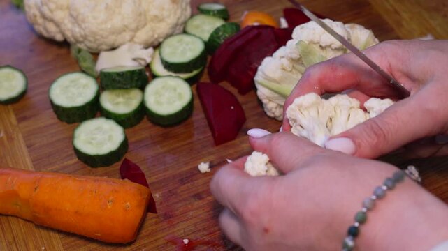 Cauliflower cooking preparation cutting fresh vegetables on wooden board for healthy meal salad in kitchen