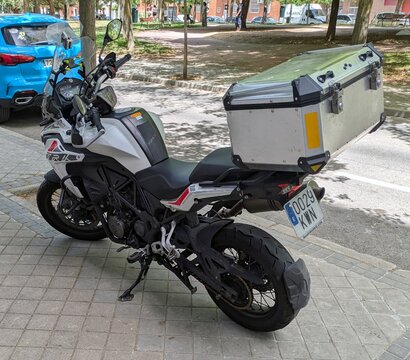 Vista lateral de moto trail adventure Benelli TRK 502 X con ba&uacute;l trasero, estacionada en Madrid, Espa&ntilde;a, 21 de junio de 2026