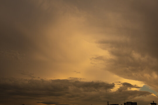 Beautiful sunset light breaking through dramatic clouds. High-contrast evening sky with sunbeams shining down through a rift in heavy cumulus clouds. Scenic natural phenomenon during golden hour.