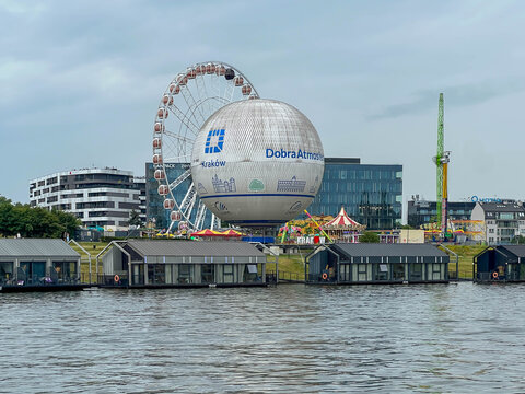 Krakow, Poland, July 26, 2025: The former Forum Hotel building in Krakow, Poland, on the Vistula River.  A balloon with the words "Good Atmosphere" is next to it