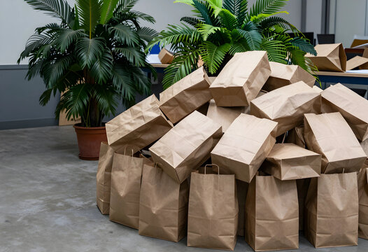 Food delivery and grocery supply chain, pile of brown paper bags for takeout or takeaway service in a modern office environment with indoor plants