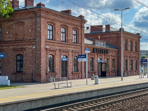 Muszkow, Poland, July 26, 2025: The railway station building in Myszkow, Poland, seen from the platforms. The red brick building is unplastered