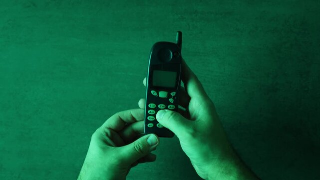 80s 90s retro vintage cell phone being used by a young adult woman, taking old mobile phone with antenna from jeans pocket.