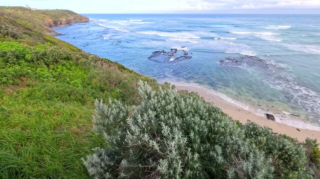 Ocean Waves Rolling Onto Coastal Beach and Cliffs