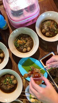 Top View of Traditional Thai Boat Noodle Bowls and Meatball Skewers