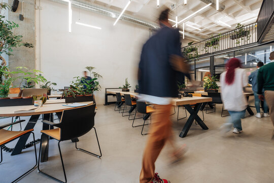 Modern coworking office with blurred people walking by