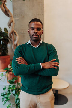 Confident young black man crossing arms indoors